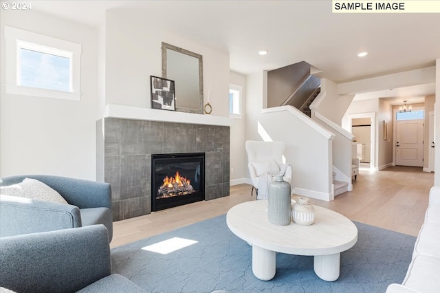 living room featuring plenty of natural light, light wood-type flooring, and a fireplace