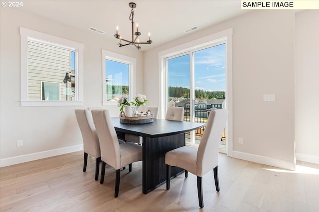 dining room featuring an inviting chandelier and light hardwood / wood-style flooring