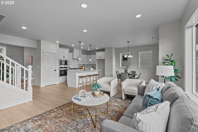 12785 SW Trask St, Beaverton, OR 97007 - living room with light wood-style floors, stairway, a chandelier, recessed lighting, and baseboards