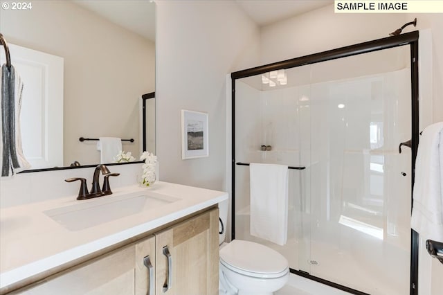 bathroom featuring vanity, toilet, and walk in shower