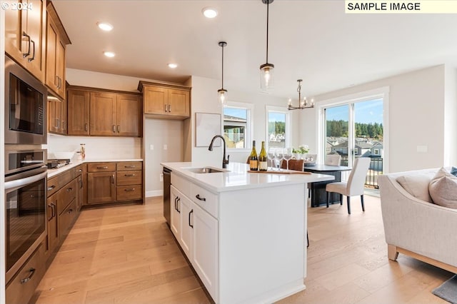 kitchen featuring white cabinets, light wood-type flooring, sink, and appliances with stainless steel finishes