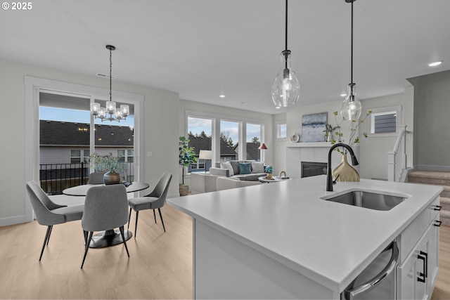 12785 SW Trask St, Beaverton, OR 97007 - kitchen featuring a sink, light wood-style floors, a tile fireplace, a chandelier, and light countertops