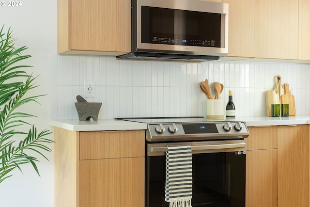 kitchen with appliances with stainless steel finishes, decorative backsplash, and light brown cabinetry