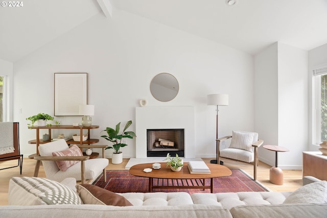 living room with beamed ceiling, high vaulted ceiling, and light wood-type flooring