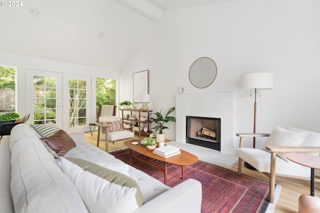 living room with beamed ceiling, light hardwood / wood-style flooring, french doors, and high vaulted ceiling