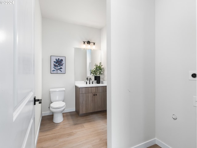 bathroom with hardwood / wood-style flooring, vanity, and toilet