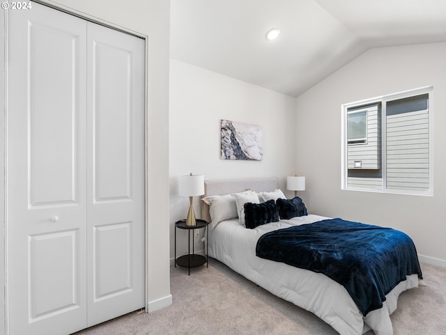 carpeted bedroom with a closet and lofted ceiling