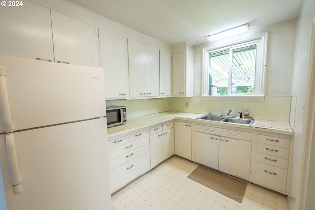 kitchen featuring white cabinets, sink, tasteful backsplash, and white fridge