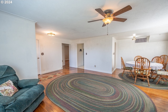 living area featuring ceiling fan, hardwood / wood-style floors, and a textured ceiling