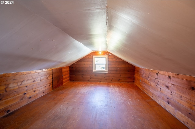 bonus room featuring wood walls, vaulted ceiling, and hardwood / wood-style flooring