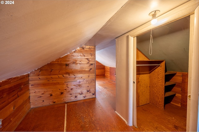 additional living space featuring lofted ceiling, wood walls, and hardwood / wood-style flooring