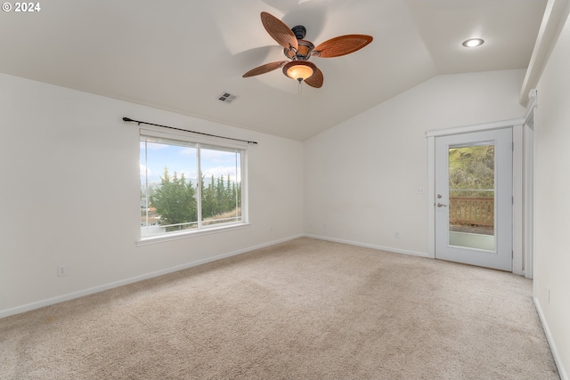 carpeted spare room with ceiling fan and vaulted ceiling