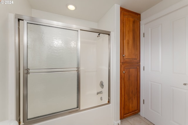 bathroom featuring tile patterned flooring and combined bath / shower with glass door