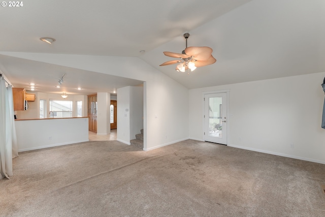 unfurnished living room featuring light carpet, lofted ceiling, ceiling fan, and a healthy amount of sunlight