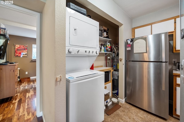 laundry room with stacked washing maching and dryer and light hardwood / wood-style floors