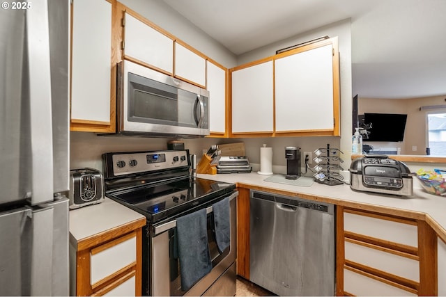 kitchen with white cabinets and appliances with stainless steel finishes