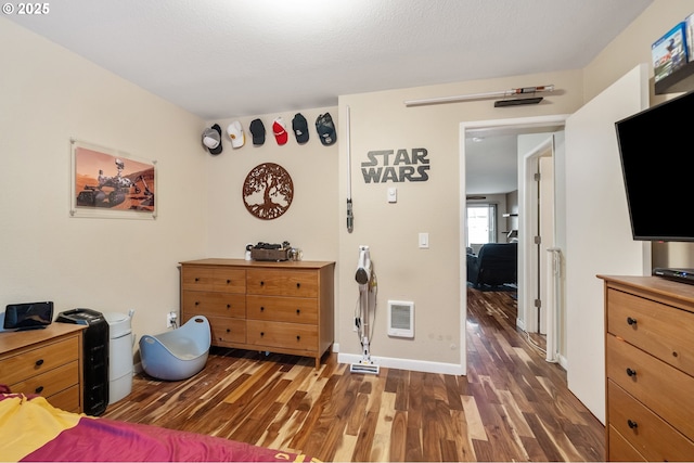 bedroom with a textured ceiling and dark wood-type flooring