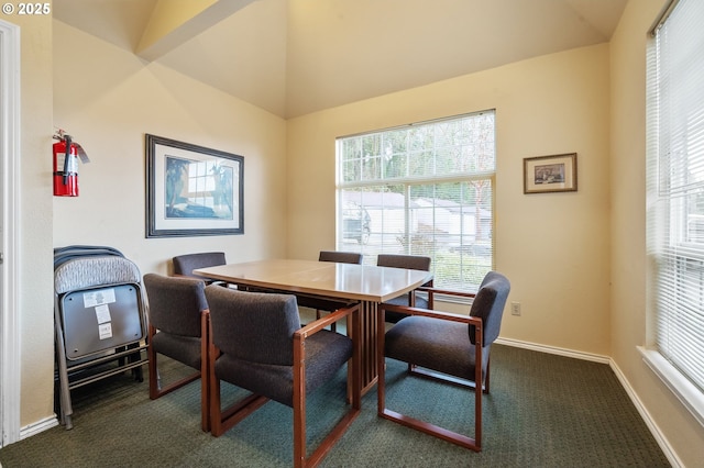 dining area featuring dark carpet and vaulted ceiling