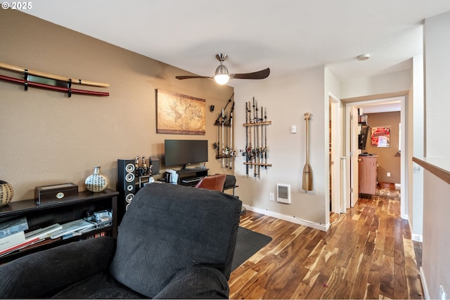 office space featuring heating unit, ceiling fan, and wood-type flooring