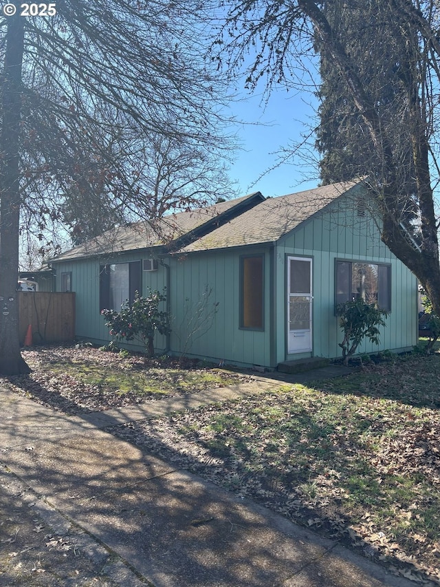 view of front of house with roof with shingles and fence