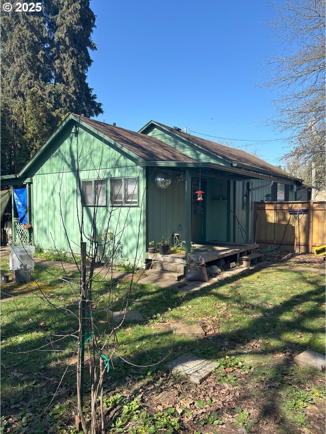 view of front of home with a front yard and fence