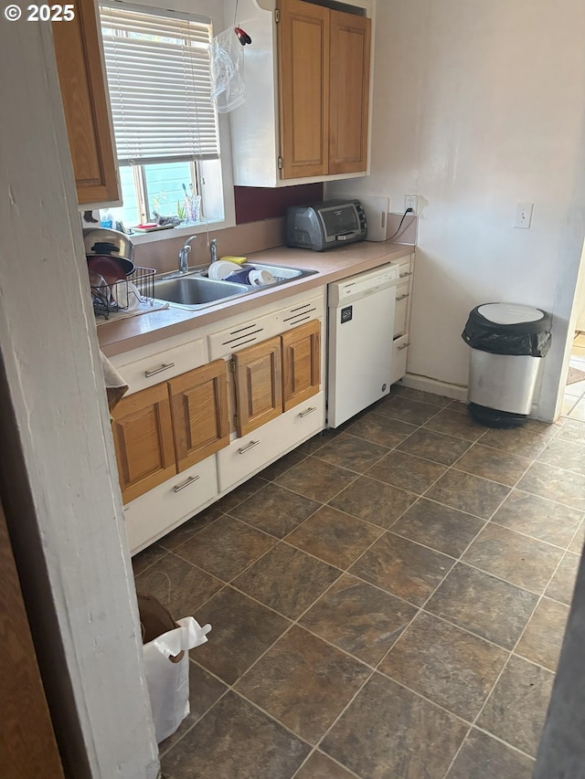 kitchen with a toaster, white dishwasher, light countertops, and a sink