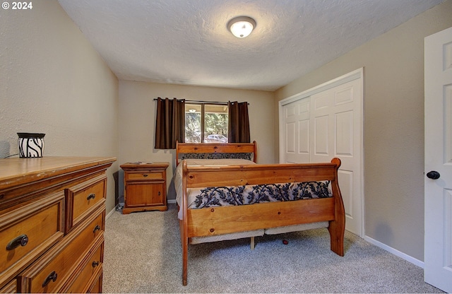 carpeted bedroom with a textured ceiling and a closet