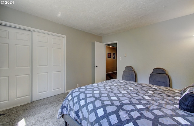 carpeted bedroom with a textured ceiling and a closet