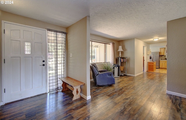 foyer featuring wood-type flooring and a textured ceiling