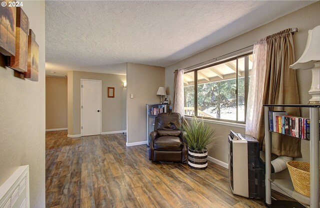 sitting room with wood-type flooring and a textured ceiling