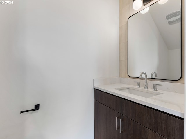 bathroom with vanity and lofted ceiling