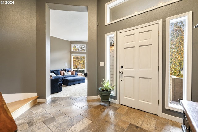 carpeted entrance foyer with ornamental molding