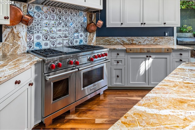 kitchen featuring tasteful backsplash, dark wood finished floors, white cabinetry, and double oven range