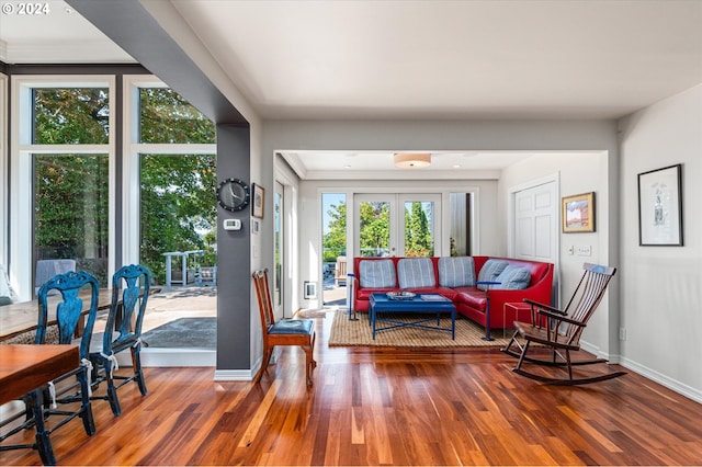 living area with french doors, baseboards, and wood finished floors