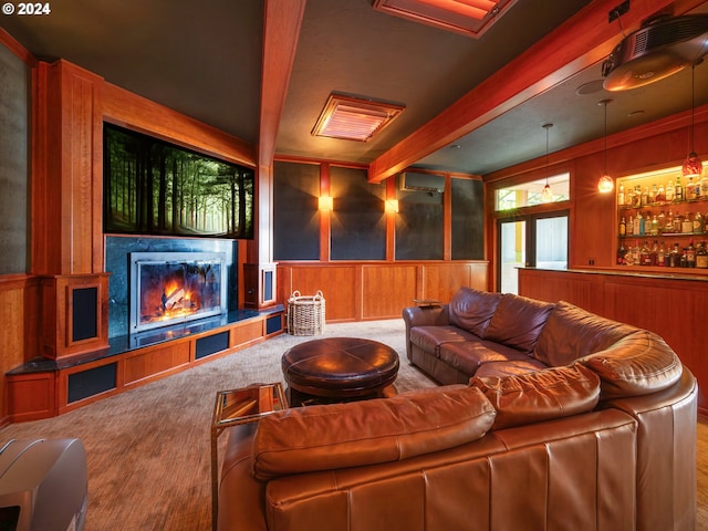 home theater featuring a wall mounted air conditioner, a decorative wall, beamed ceiling, and a glass covered fireplace