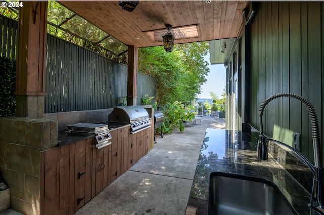 view of patio with area for grilling, a sink, and a ceiling fan