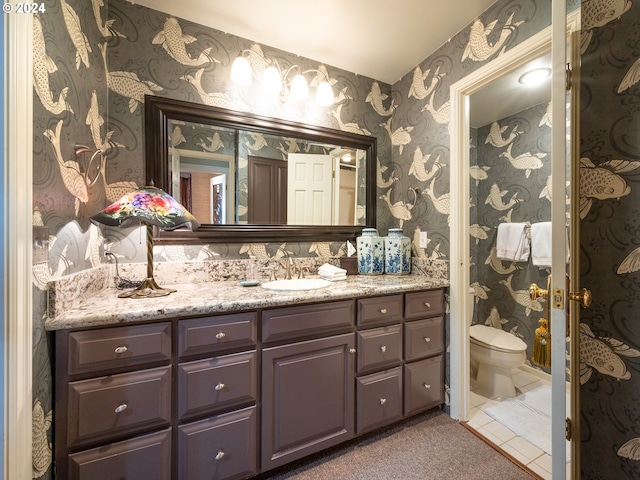 bathroom with toilet, wallpapered walls, tile patterned floors, and vanity