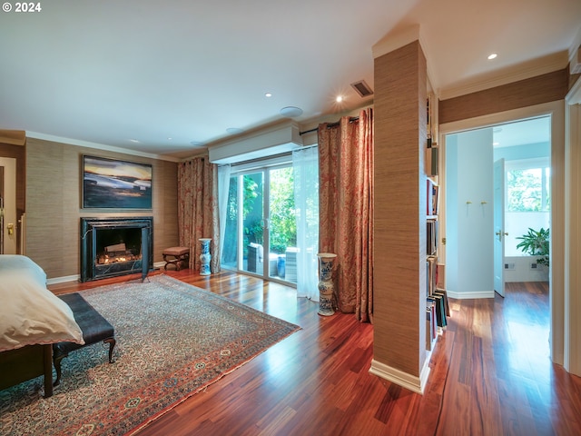 living room with visible vents, wood finished floors, a lit fireplace, crown molding, and recessed lighting