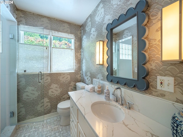 full bathroom featuring vanity, a shower stall, toilet, and wallpapered walls