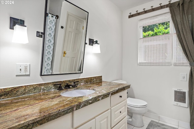 full bath featuring heating unit, toilet, vanity, baseboards, and tile patterned floors