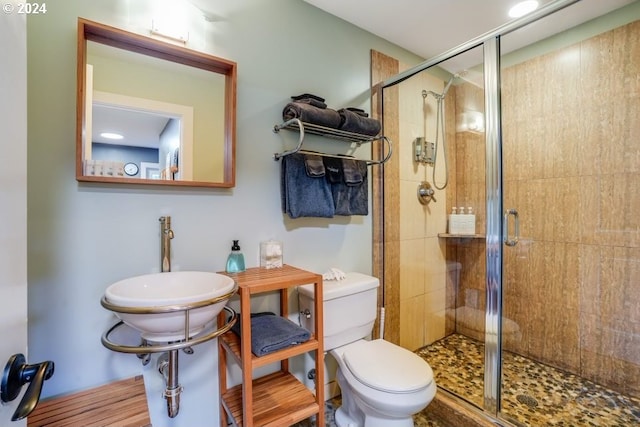 bathroom featuring toilet, hardwood / wood-style floors, a shower with shower door, and sink