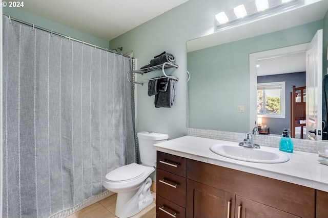 bathroom with walk in shower, vanity, toilet, and tile patterned flooring