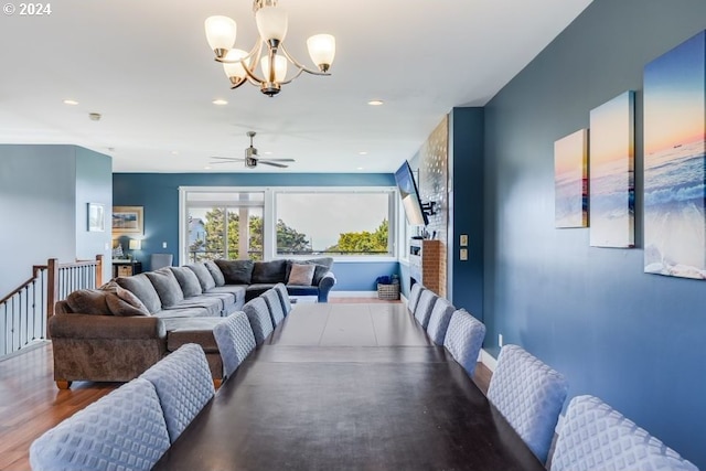 dining space featuring hardwood / wood-style floors and ceiling fan with notable chandelier