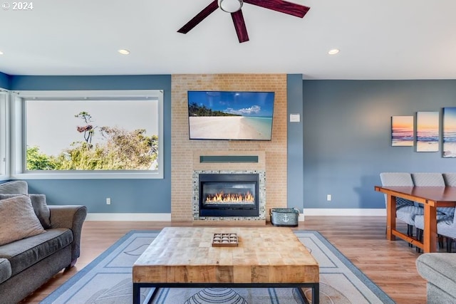 living room with hardwood / wood-style floors, a fireplace, and ceiling fan