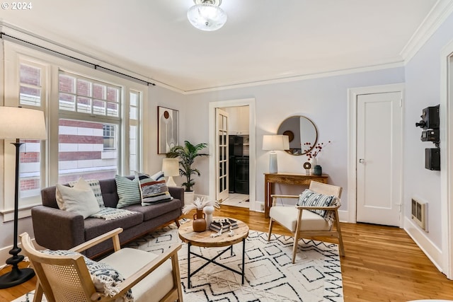 living room featuring light wood-type flooring and crown molding