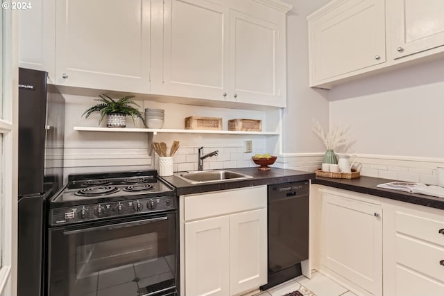 kitchen featuring light tile patterned floors, sink, white cabinets, and black appliances