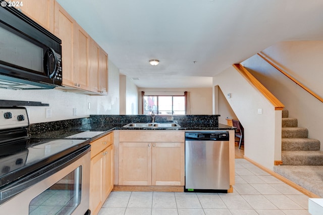 kitchen featuring appliances with stainless steel finishes, sink, light brown cabinetry, and kitchen peninsula