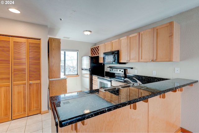 kitchen with appliances with stainless steel finishes, a kitchen breakfast bar, and kitchen peninsula