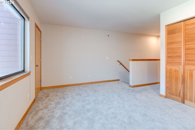 unfurnished bedroom featuring light carpet and a closet