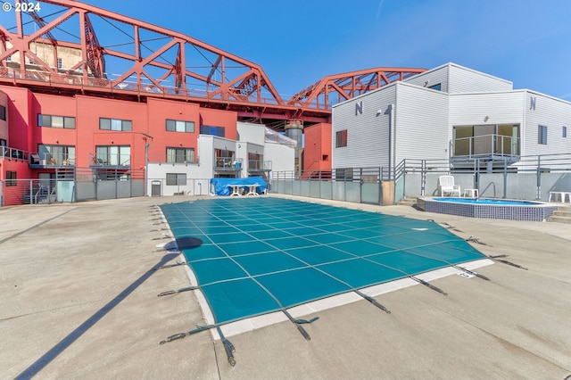 view of swimming pool with a hot tub